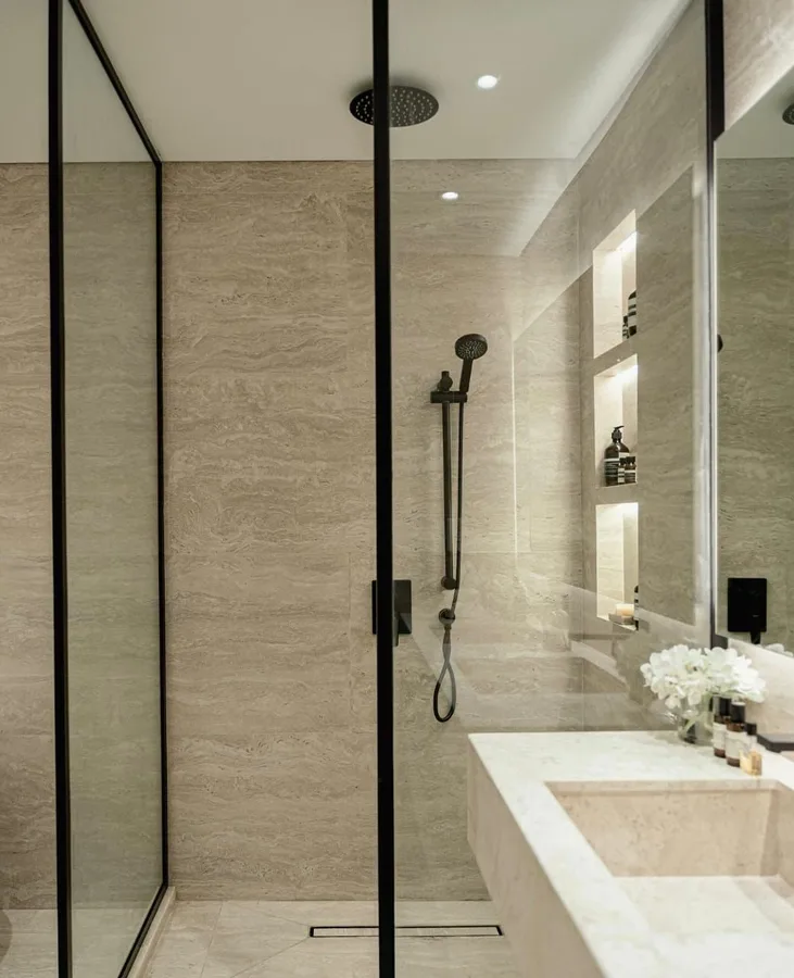 Frameless glass shower enclosure with black aluminium framing in a Dubai villa